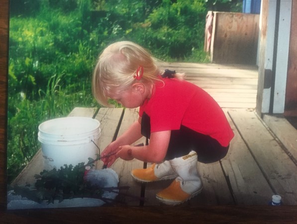 My daughter cleaning the kale she grew in her garden patch